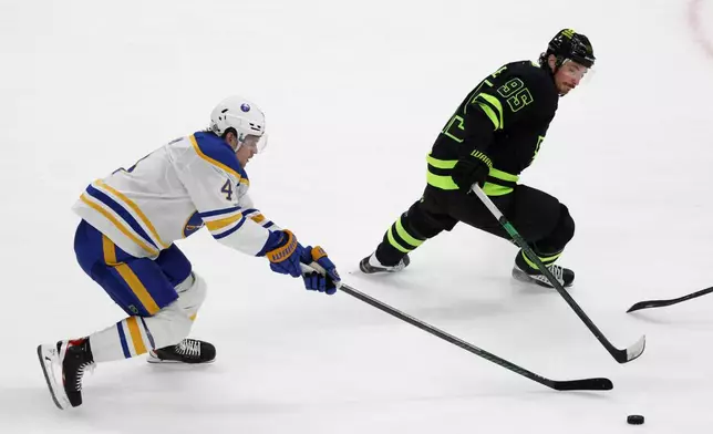 Buffalo Sabres defenseman Bowen Byram (4) and Dallas Stars center Matt Duchene (95) battle for the puck during the second period of an NHL hockey game in Dallas, Tuesday, Dec. 31, 2024. (AP Photo/Michael Ainsworth)