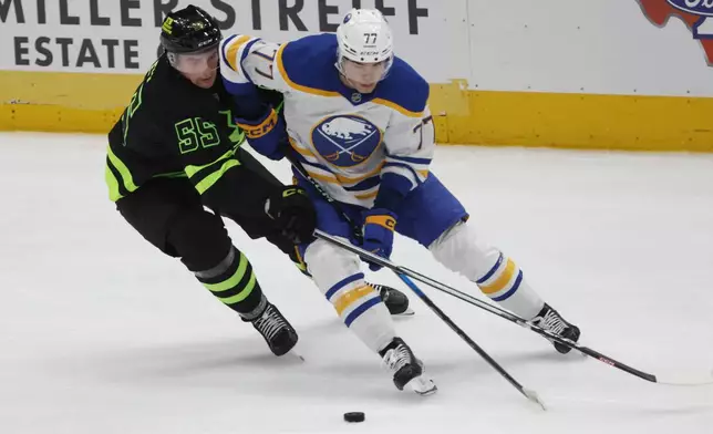 Dallas Stars defenseman Thomas Harley (55) and Buffalo Sabres right wing JJ Peterka (77) fight for the puck during the second period of an NHL hockey game in Dallas, Tuesday, Dec. 31, 2024. (AP Photo/Michael Ainsworth)