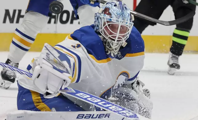 Buffalo Sabres goaltender Ukko-Pekka Luukkonen (1) diverts a shot on goal by the Dallas Stars during the first period of an NHL hockey game in Dallas, Tuesday, Dec. 31, 2024. (AP Photo/Michael Ainsworth)