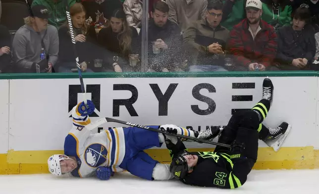 Buffalo Sabres center Sam Lafferty and Dallas Stars center Roope Hintz (24) crash into the boards during the second period of an NHL hockey game in Dallas, Tuesday, Dec. 31, 2024. (AP Photo/Michael Ainsworth)