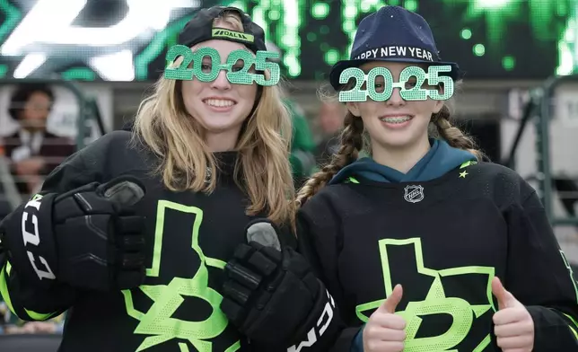 Lauren Spurgin, left, and Kate Spurgin, of Dallas, wear festive New Year's glasses prior to an NHL hockey game between the Buffalo Sabres and the Dallas Stars in Dallas, Tuesday, Dec. 31, 2024. (AP Photo/Michael Ainsworth)