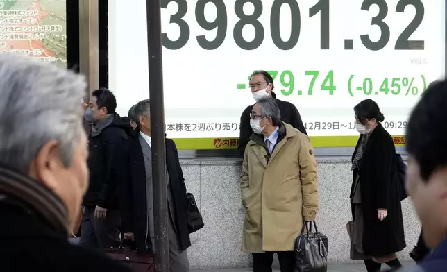 People stand near an electronic stock board showing Japan's Nikkei index at a securities firm Thursday, Jan. 9, 2025, in Tokyo. (AP Photo/Eugene Hoshiko)