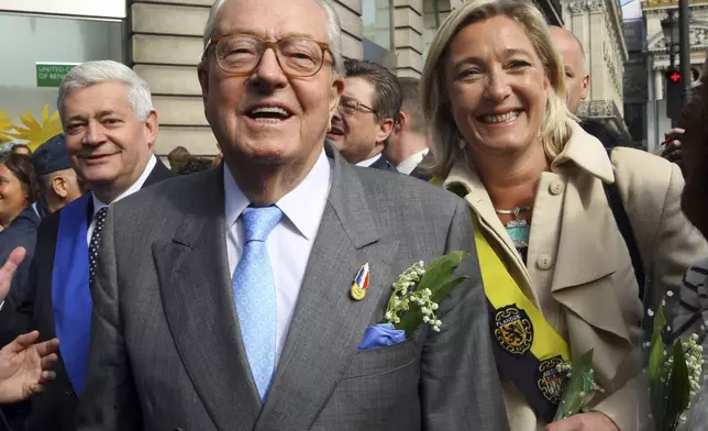 FILE - French far-right leader Jean-Marie Le Pen, center, flanked by his daughter Marine Le Pen, and Bruno Gollnisch, arrives for a wreath-laying ceremony at the statue of Joan of Arc, within the party's traditional May Day march Saturday May 1, 2010, in Paris.(AP Photo/Jacques Brinon, File)