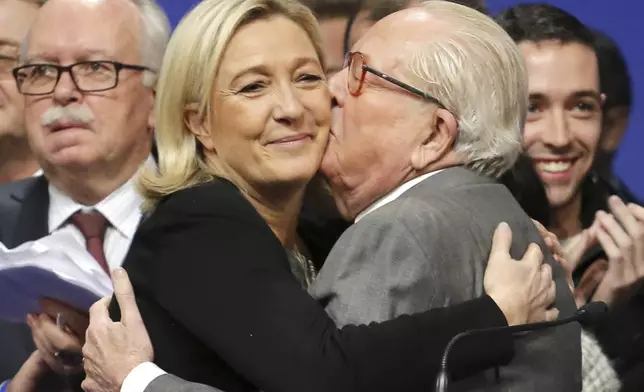 FILE - French far-right Front National leader Marine Le Pen is kissed by her father Jean-Marie Le Pen, in Lyon, central France, Sunday Nov. 30, 2014. (AP Photo/Laurent Cipriani, File)