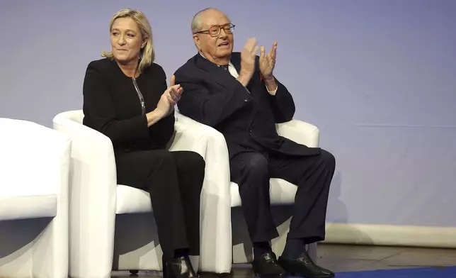 FILE- French far-right Front National leader Marine Le Pen and her father Jean-Marie Le Pen applaud during the 15th congress of the party, in Lyon, central France, Saturday Nov. 29, 2014. (AP Photo/Laurent Cipriani, File)