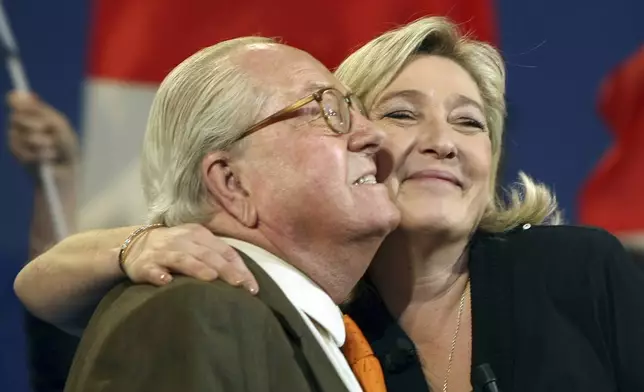 FILE- Honorary President of far-right party National Front Jean-Marie Le Pen, left, and his daughter French far-right leader and National Front Party candidate for the 2012 French presidential elections, Marine Le Pen, during a campaign meeting in Marseille, southern France, Sunday, March 4, 2012. (AP Photo/Claude Paris, File)