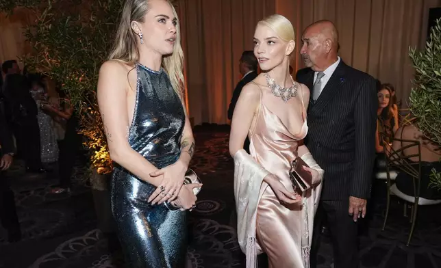 Cara Delevingne, left, and Anya Taylor-Joy arrive at the 82nd Golden Globes on Sunday, Jan. 5, 2025, at the Beverly Hilton in Beverly Hills, Calif. (AP Photo/Chris Pizzello)