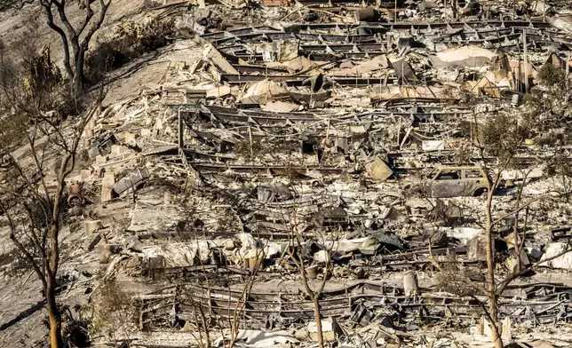 Homes and vehicles destroyed by the Palisades Fire line a mobile home park along the Pacific Coast Highway on Sunday, Jan. 12, 2025, in Los Angeles. (AP Photo/Noah Berger)