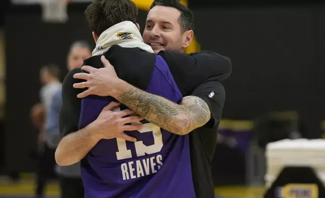 Los Angeles Lakers NBA basketball head coach JJ Redick, right, is hugged by guard Austin Reaves, left before talking to the media about the Pacific Palisades wildfire at a news conference in El Segundo, Calif., Friday, Jan. 10, 2025. (AP Photo/Damian Dovarganes)