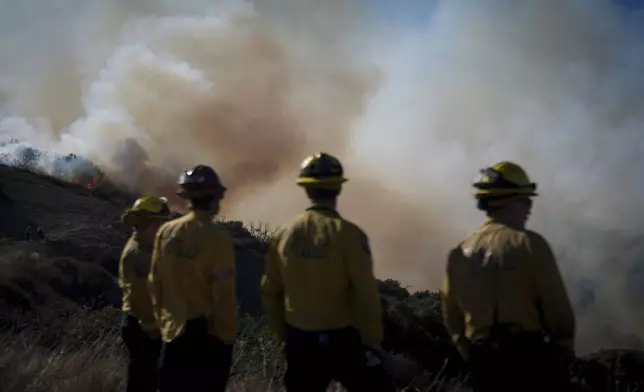 Fire crews monitor the Palisades Fire in the outskirts of the Pacific Palisades neighborhood of Los Angeles, Friday, Jan. 10, 2025. (AP Photo/Eric Thayer)