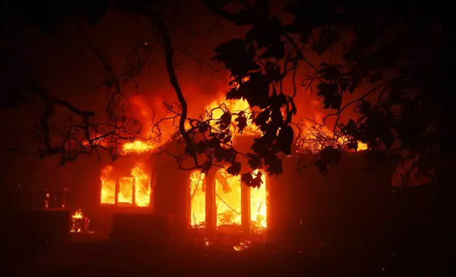 A structures burns as the Palisades Fire sweeps through in the Pacific Palisades neighborhood of Los Angeles, Tuesday, Jan. 7, 2025. (AP Photo/Etienne Laurent)