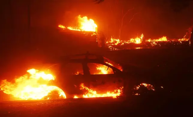 A vehicle burns as the Palisades Fire sweeps through in the Pacific Palisades neighborhood of Los Angeles, Tuesday, Jan. 7, 2025. (AP Photo/Etienne Laurent)