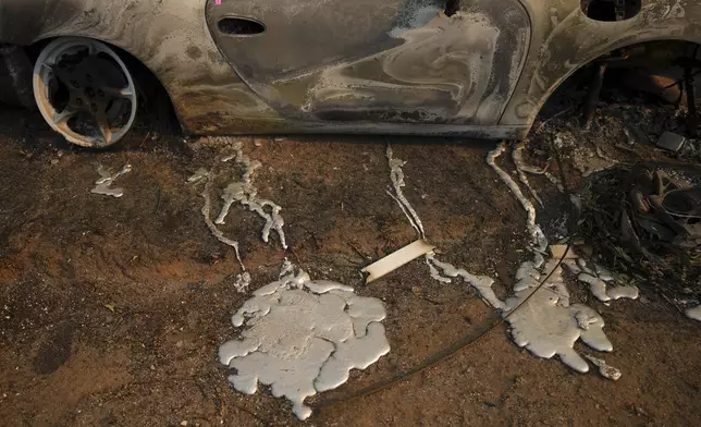 Melted metal from a burned vehicle is seen on the ground of a property in the aftermath of the Palisades Fire in the Pacific Palisades neighborhood of Los Angeles, Friday, Jan. 10, 2025. (AP Photo/Eric Thayer)