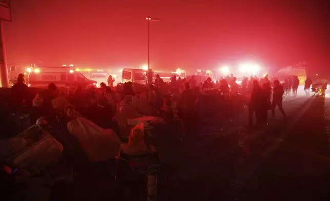 Residents of a senior center are evacuated as the Eaton Fire approaches Tuesday, Jan. 7, 2025 in Altadena, Calif. (AP Photo/Ethan Swope)