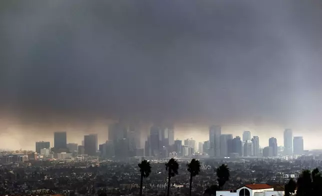 Thick heavy smoke from wildfires shrouds downtown Los Angeles on Wednesday, Jan. 8, 2025. (AP Photo/Richard Vogel)