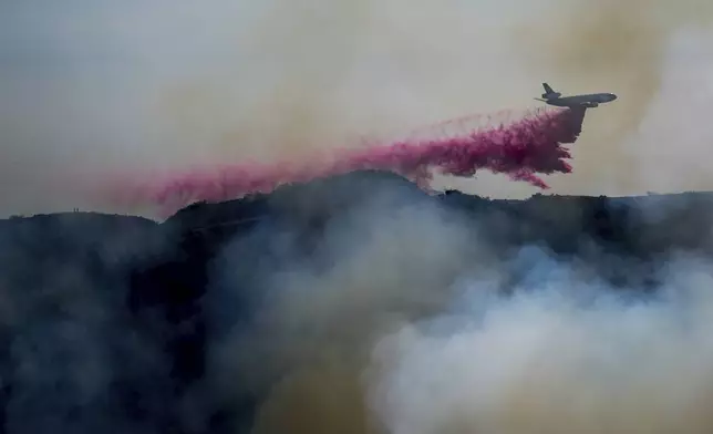 Retardant is dropped by air tanker on the Palisades Fire in the outskirts of the Pacific Palisades neighborhood of Los Angeles, Friday, Jan. 10, 2025. (AP Photo/Eric Thayer)