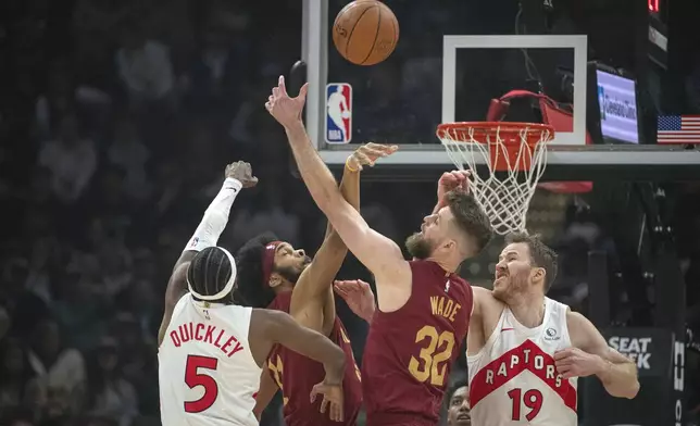 Toronto Raptors' Immanuel Quickley (5), Cleveland Cavaliers' Jarrett Allen, center left, Cavaliers' Dean Wade (32) and Raptors' Jakob Poeltl (19) vie for a rebound during the first half of an NBA basketball game in Cleveland, Thursday, Jan. 9, 2025. (AP Photo/Phil Long)