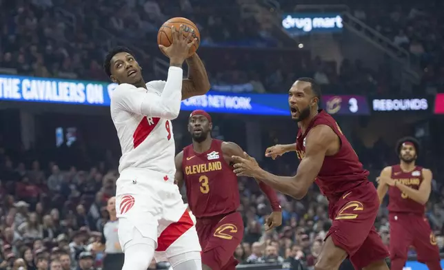 Toronto Raptors' RJ Barrett, left, grabs the ball as Cleveland Cavaliers' Evan Mobley, front left, reacts and Caris LeVert (3) watches during the first half of an NBA basketball game in Cleveland, Thursday, Jan. 9, 2025. (AP Photo/Phil Long)