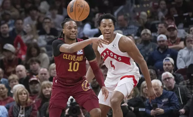 Cleveland Cavaliers' Darius Garland (10) passes the ball as Toronto Raptors' Scottie Barnes (4) defends during the first half of an NBA basketball game in Cleveland, Thursday, Jan. 9, 2025. (AP Photo/Phil Long)