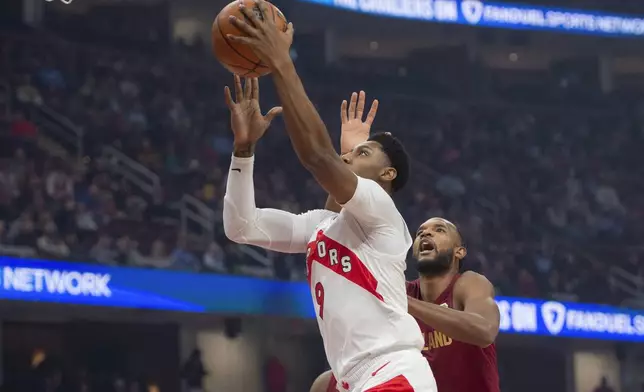 Toronto Raptors' RJ Barrett (9) drives to the basket as Cleveland Cavaliers' Evan Mobley, right, defends during the first half of an NBA basketball game in Cleveland, Thursday, Jan. 9, 2025. (AP Photo/Phil Long)