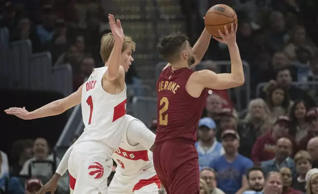 Cleveland Cavaliers' Ty Jerome (2) shoots as Toronto Raptors' Gradey Dick (1) backs away during the first half of an NBA basketball game in Cleveland, Thursday, Jan. 9, 2025. (AP Photo/Phil Long)