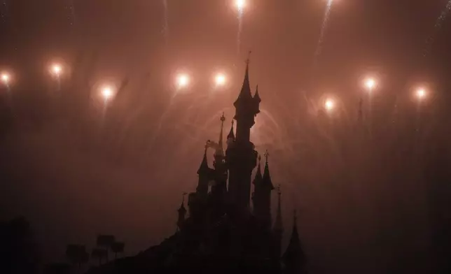A firework display lights up the castle of Sleeping Beauty in Disneyland, in Marne-la-Vallee, east of Paris, Friday Jan. 17, 2025. (AP Photo/Thibault Camus)