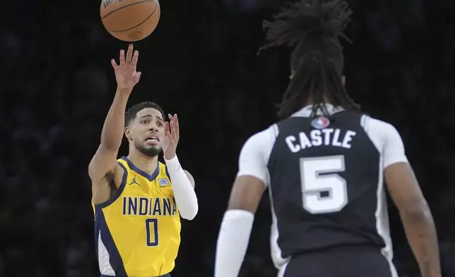 Indiana Pacers guard Tyrese Haliburton (0) passes the ball against San Antonio Spurs guard Stephon Castle (5) during the first half of a Paris Games 2025 NBA basketball game in Paris, Thursday, Jan. 23, 2025. (AP Photo/Thibault Camus)