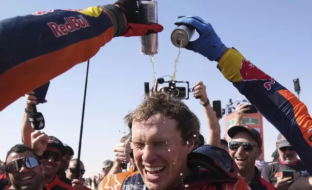 Rider Daniel Sanders of Australia celebrates winning the Dakar Rally after the twelfth stage in Shubaytah, Saudi Arabia, Friday, Jan. 17, 2025. (AP Photo/Christophe Ena)