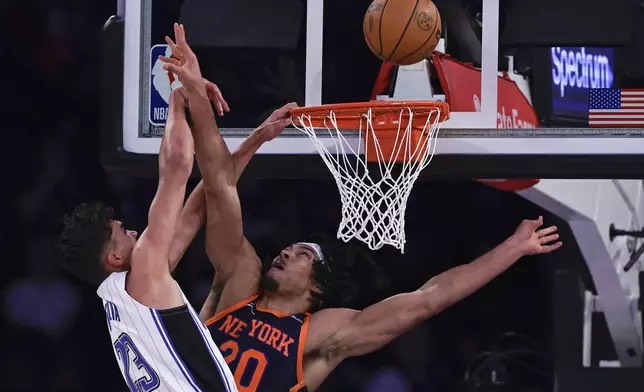 New York Knicks center Jericho Sims (20) defends against a shot by Orlando Magic forward Tristan da Silva (23) during the first half of an NBA basketball game Monday, Jan. 6, 2025, in New York. (AP Photo/Adam Hunger)