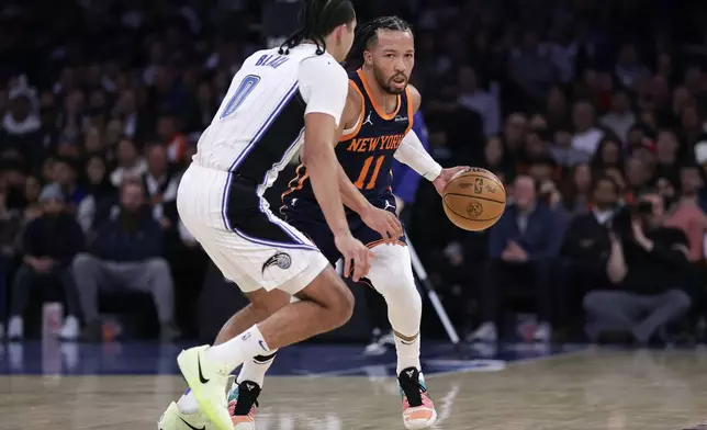 New York Knicks guard Jalen Brunson (11) drives past Orlando Magic guard Caleb Houstan, left, during the first half of an NBA basketball game Monday, Jan. 6, 2025, in New York. (AP Photo/Adam Hunger)