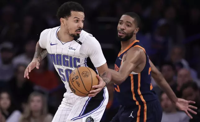 Orlando Magic guard Cole Anthony (50) drives against New York Knicks forward Mikal Bridges, right, during the first half of an NBA basketball game Monday, Jan. 6, 2025, in New York. (AP Photo/Adam Hunger)