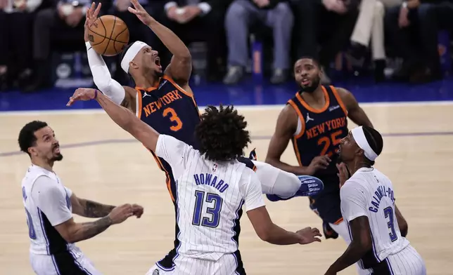 New York Knicks guard Josh Hart (3) is fouled by Orlando Magic guard Jett Howard (13) while driving to the basket during the first half of an NBA basketball game Monday, Jan. 6, 2025, in New York. (AP Photo/Adam Hunger)