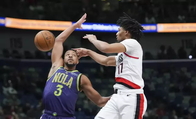 Portland Trail Blazers guard Shaedon Sharpe (17) passes around New Orleans Pelicans guard CJ McCollum (3) in the first half of an NBA basketball game in New Orleans, Wednesday, Jan. 8, 2025. (AP Photo/Gerald Herbert)