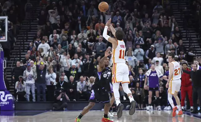 Atlanta Hawks guard Trae Young (11) shoots a three point shot from half court over Utah Jazz guard Collin Sexton (2) at the buzzer to win an NBA basketball game, Tuesday, Jan. 7, 2025, in Salt Lake City. (AP Photo/Rob Gray)