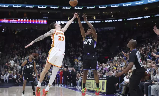 Utah Jazz guard Collin Sexton (2) shoots a three-point shot over Atlanta Hawks guard Vit Krejci (27) to tie the game with three seconds left in an NBA basketball game, Tuesday, Jan. 7, 2025, in Salt Lake City. (AP Photo/Rob Gray)