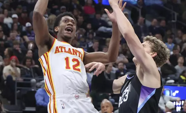 Atlanta Hawks forward De'Andre Hunter (12) shoots against Utah Jazz forward Lauri Markkanen (23) during the first quarter of an NBA basketball game, Tuesday, Jan. 7, 2025, in Salt Lake City. (AP Photo/Rob Gray)