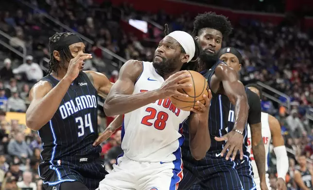 Detroit Pistons center Isaiah Stewart (28) is defended by Orlando Magic center Wendell Carter Jr. (34) during the first half of an NBA basketball game, Wednesday, Jan. 1, 2025, in Detroit. (AP Photo/Carlos Osorio)