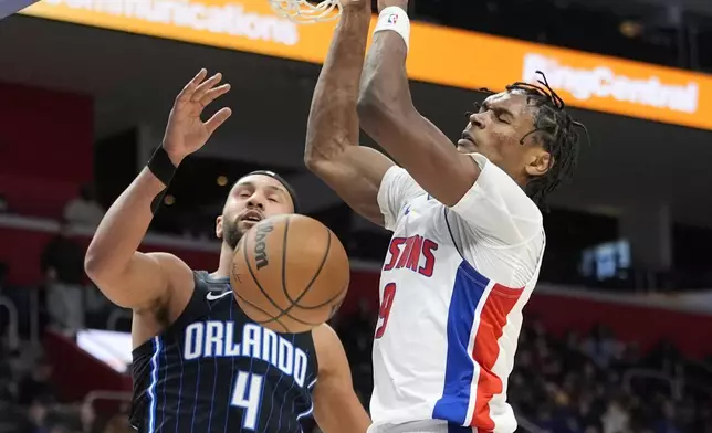 Detroit Pistons forward Ausar Thompson (9) dunks as Orlando Magic guard Jalen Suggs (4) defends during the first half of an NBA basketball game, Wednesday, Jan. 1, 2025, in Detroit. (AP Photo/Carlos Osorio)