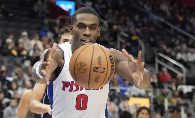 Detroit Pistons center Jalen Duren (0) reaches for the loose ball during the first half of an NBA basketball game against the Orlando Magic, Wednesday, Jan. 1, 2025, in Detroit. (AP Photo/Carlos Osorio)