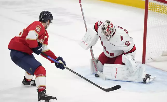 Florida Panthers center Aleksander Barkov (16) attempts a shot at Carolina Hurricanes goaltender Pyotr Kochetkov (52) during the second period of an NHL hockey game, Thursday, Jan. 2, 2025, in Sunrise, Fla. (AP Photo/Wilfredo Lee)