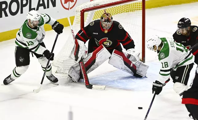 Dallas Stars' center Colin Blackwell (15) tries to set up a shot for teammate Sam Steel (18) in front of Ottawa Senators goaltender Leevi Merilainen (1) during third-period NHL hockey game action in Ottawa, Ontario, Sunday, Jan. 12, 2025. (Justin Tang/The Canadian Press via AP)