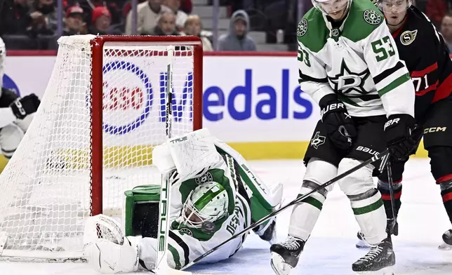 Dallas Stars goaltender Casey DeSmith, bottom left, allows a goal by Ottawa Senators' Tim Stutzle (not shown) during second-period NHL hockey game action in Ottawa, Ontario, Sunday, Jan. 12, 2025. (Justin Tang/The Canadian Press via AP)