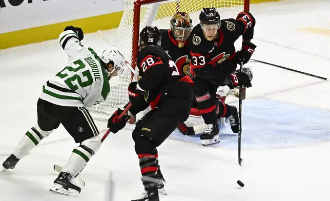 Ottawa Senators' Nikolas Matinpalo (33) works to clear the puck away as teammate Claude Giroux (28) holds off Dallas Stars' Mavrik Bourque (22) during third-period NHL hockey game action in Ottawa, Ontario, Sunday, Jan. 12, 2025. (Justin Tang/The Canadian Press via AP)