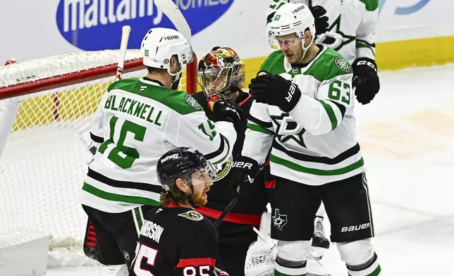 Ottawa Senators goaltender Leevi Merilainen, center top, looks on as Dallas Stars' Evgenii Dadonov (63) celebrates after scoring Stars' Colin Blackwell (15) during third-period NHL hockey game action in Ottawa, Ontario, Sunday, Jan. 12, 2025. (Justin Tang/The Canadian Press via AP)