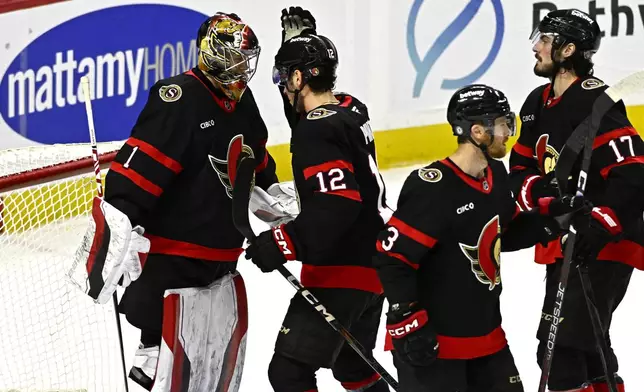 Ottawa Senators goaltender Leevi Merilainen (1) celebrate with teammate Shane Pinto (12) at the end of NHL hockey game action against the Dallas Stars in Ottawa, Ontario, Sunday, Jan. 12, 2025. (Justin Tang/The Canadian Press via AP)