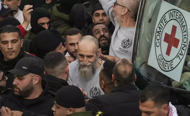 Palestinian Raed Al-Saadi, 57, center, and other prisoner are greeted by a crowd after being released from Israeli prison following a ceasefire agreement with Israel, in the West Bank city of Ramallah, Saturday, Jan. 25, 2025. (AP Photo/Mahmoud Illean)