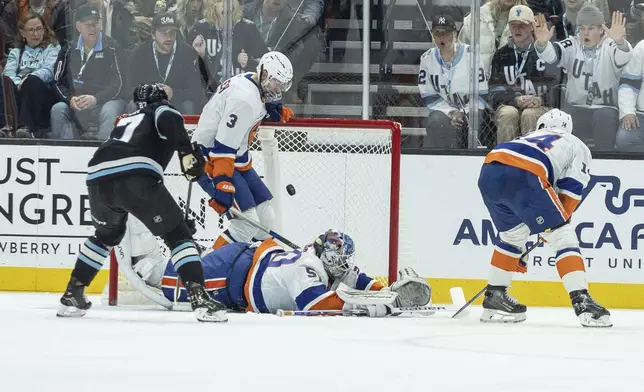 New York Islanders defenseman Adam Pelech (3) and goalie Marcus Hogberg (50) blocks the goal against Utah Hockey Club center Clayton Keller (9) during the second period of an NHL hockey game Saturday, Jan. 11, 2025, in Salt Lake City. (AP Photo/Melissa Majchrzak)