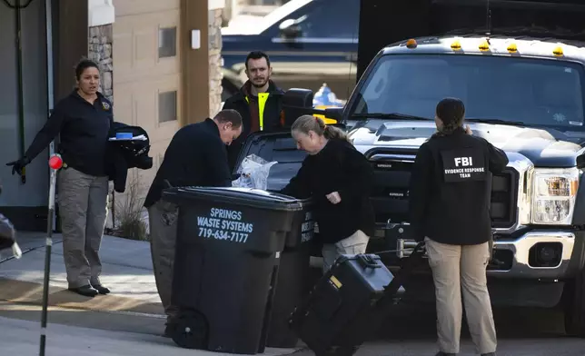 Investigators search the garbage outside of a townhouse in northeastern Colorado Springs, Colo., Thursday, Jan. 2, 2025, as the investigation connected to the explosion of a Tesla Cybertruck outside President-elect Donald Trump's Las Vegas hotel continues. (Parker Seibold /The Gazette via AP)