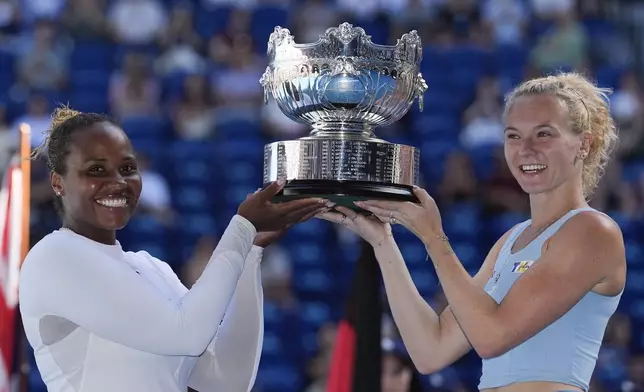 Katerina Sinikova of the Czech Republic and Taylor Townsend of the U.S. hold their trophy aloft after defeating Hsieh Su-Wei of Taiwan and Jelena Ostapenko of Latvia in the women's doubles final at the Australian Open tennis championship in Melbourne, Australia, Sunday, Jan. 26, 2025. (AP Photo/Asanka Brendon Ratnayake)