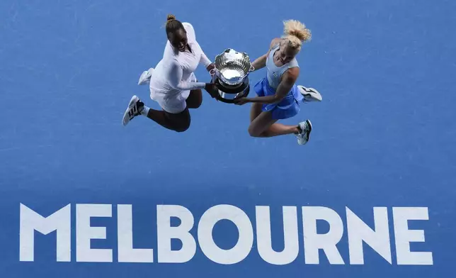 Katerina Sinikova, right, of the Czech Republic and Taylor Townsend of the U.S. jump with their trophy after defeating Hsieh Su-Wei of Taiwan and Jelena Ostapenko of Latvia in the women's doubles final at the Australian Open tennis championship in Melbourne, Australia, Sunday, Jan. 26, 2025. (AP Photo/Manish Swarup)